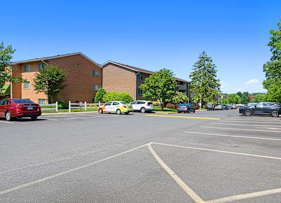 a parking lot with cars parked in front of a building at Gainsborough Court Apartments, Virginia, 22030