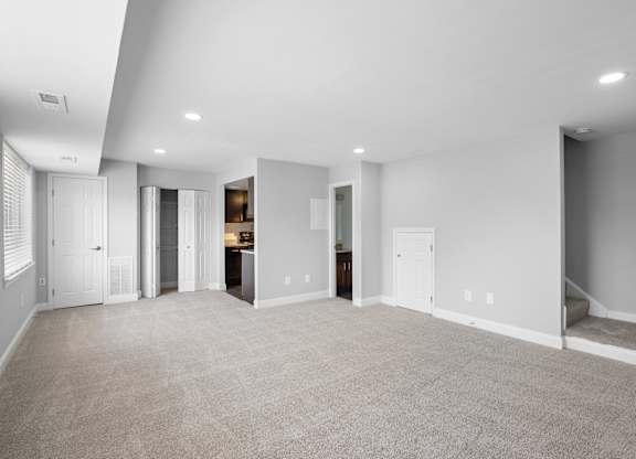a living room with a carpeted floor and white walls at Gainsborough Court Apartments, Fairfax