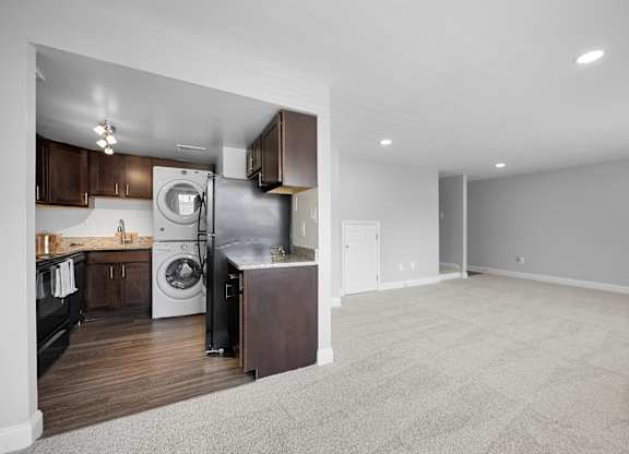 a renovated living room with a washer and dryer and a kitchen at Gainsborough Court Apartments, Fairfax, VA