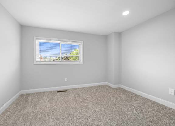 an empty room with carpet and a window at Gainsborough Court Apartments, Fairfax, Virginia