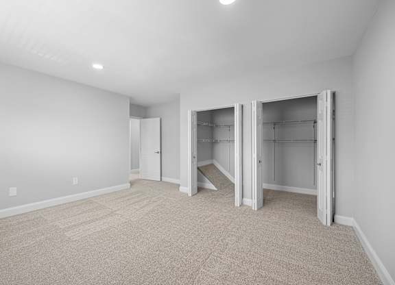a room with a carpeted floor and a closet with mirrored doors at Gainsborough Court Apartments, Fairfax