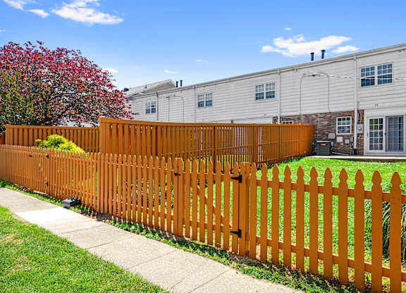 a wooden fence in front of a house at Gainsborough Court Apartments, Fairfax, VA, 22030