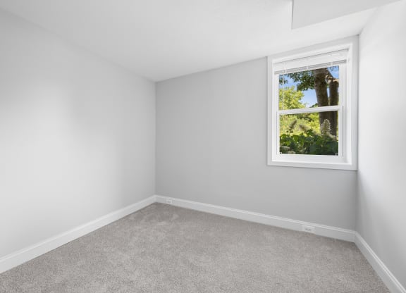 an empty room with white walls and a window