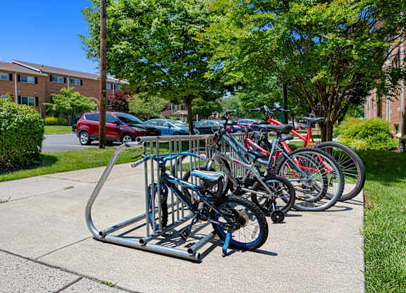 a row of bikes parked on a bike rack on a sidewalk at Gainsborough Court Apartments, Virginia, 22030