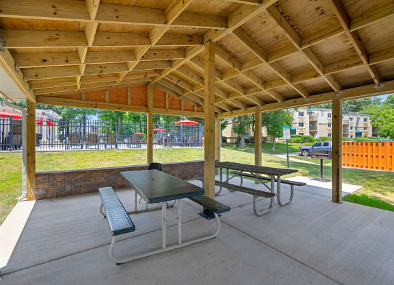 two picnic tables under a pavilion in a park