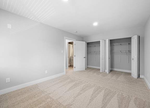 a living room with white walls and carpet and a closet with doors at Gainsborough Court Apartments, Fairfax, 22030