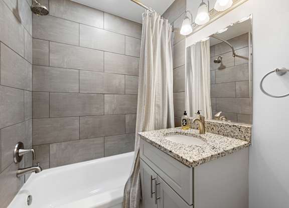 a bathroom with a sink and a shower and a tub at Gainsborough Court Apartments, Fairfax