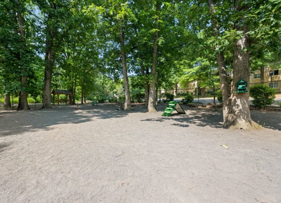 a park with trees and a green bench