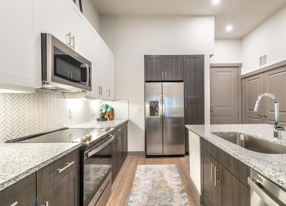 A Large Kitchen With Granite Counter Tops and Stainless Steel Appliances at The Bridge at McKinney, McKinney, Texas, 75069