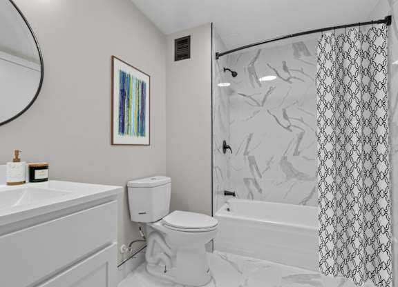 A bathroom with a toilet, sink, and shower.