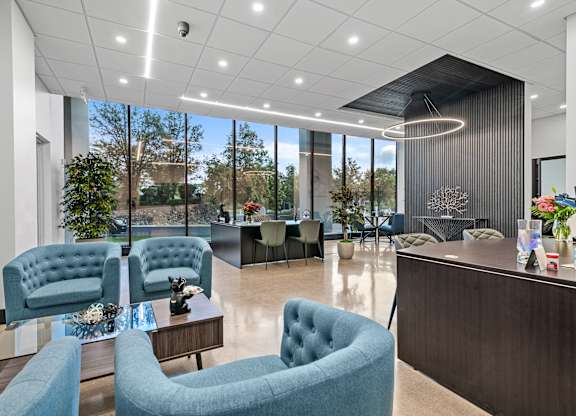 A modern office lobby with blue chairs and a reception desk.