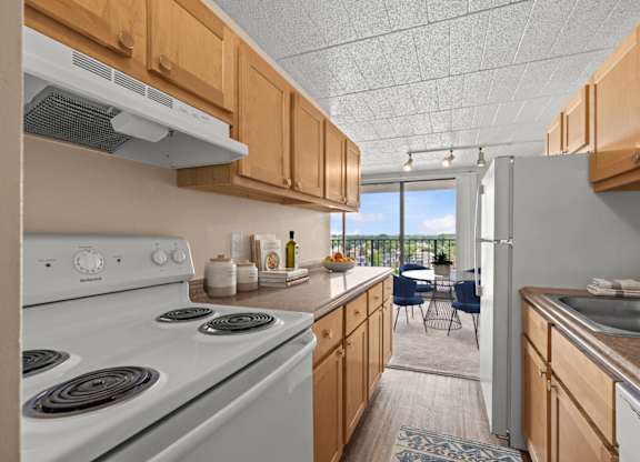 A kitchen with a white stove and wooden cabinets.