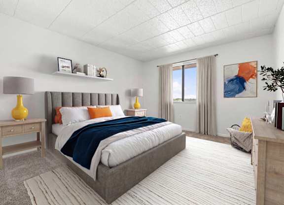 A bedroom with a large bed and a window with curtains.
