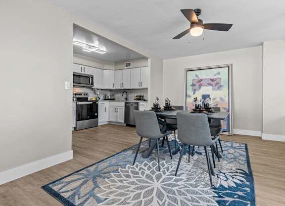 A dining room with a table set for four.