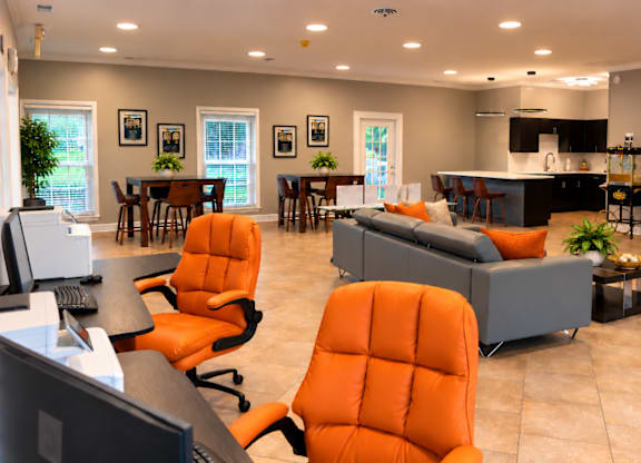 A modern living room with orange chairs and a fireplace.