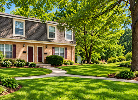 A house with a red door and a green lawn.