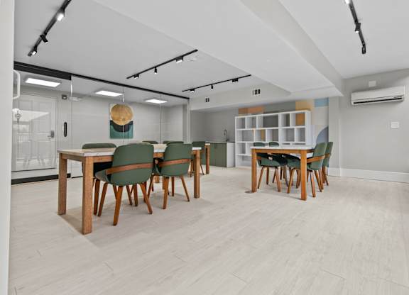 A conference room with a long table and green chairs.