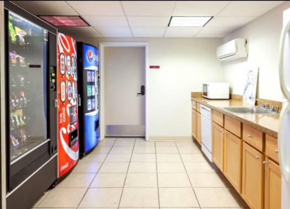 A kitchen area with a Coca-Cola vending machine on the left.