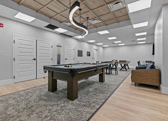 A room with a pool table and a bench.