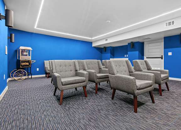 A room with blue walls and grey chairs.
