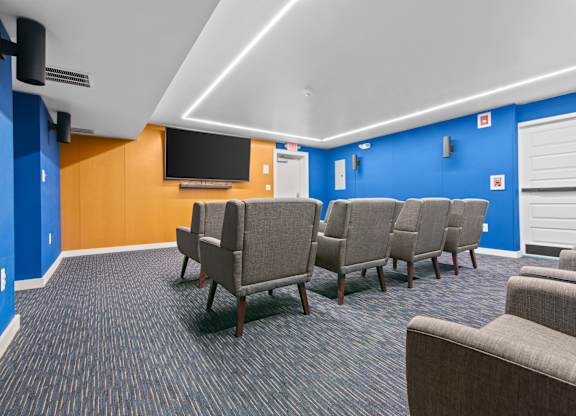A room with blue walls and a row of grey chairs.