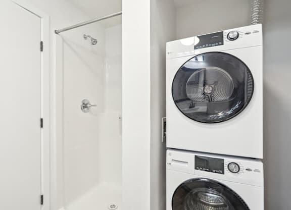 A white washing machine is placed next to a white door.