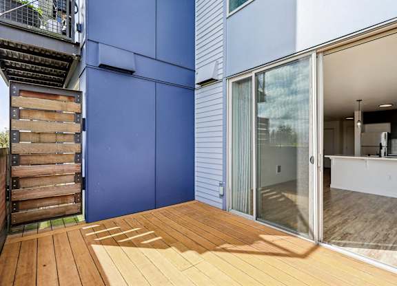 A blue wall with a wooden deck in front.