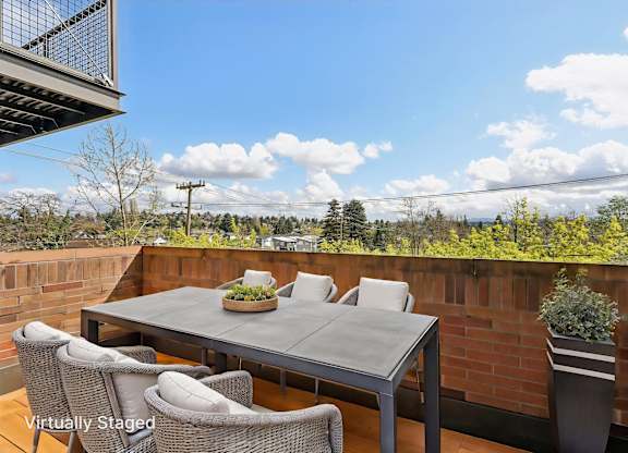 A patio with a table and chairs overlooking a landscape.