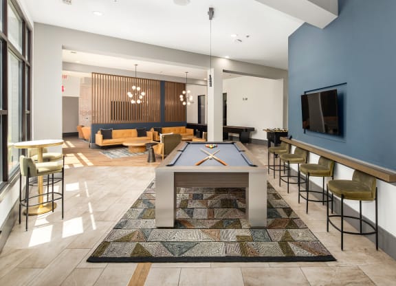 a spacious game room with a pool table and a television