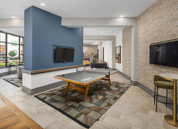 a living room with a ping pong table and a television