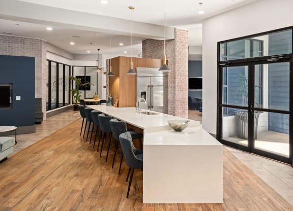 a large kitchen with a large island and a long table with chairs