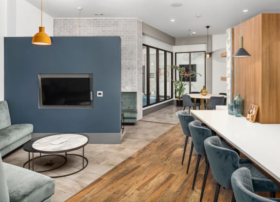 a living room with a blue accent wall and a long table with chairs
