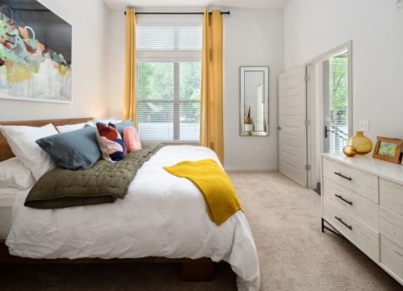a bedroom with a bed and a dresser and a window