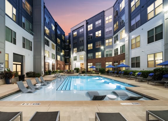 a swimming pool in front of an apartment building with a pool