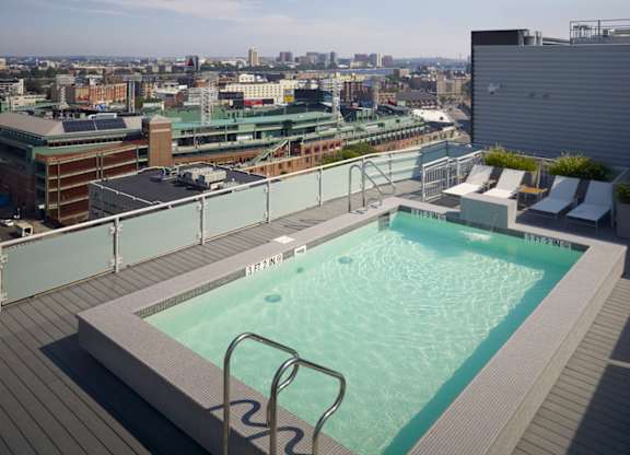 A rooftop pool with a cityscape in the background.
