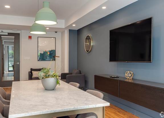 A modern dining room with a marble table and grey chairs.