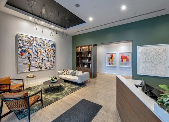 A reception area with a large painting on the wall and a couch.