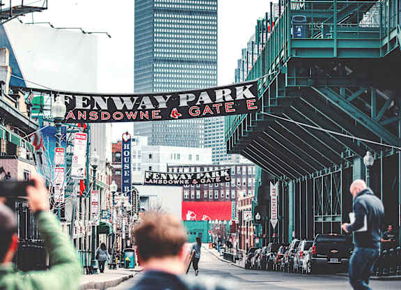 A man is taking a photo of a street with a sign that reads
