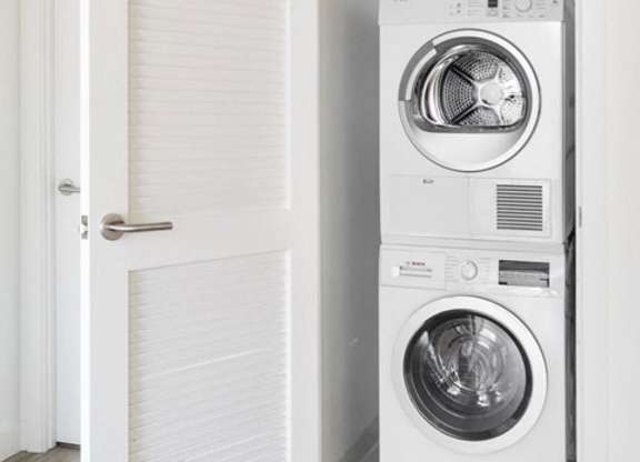 A white washing machine is in a small room.