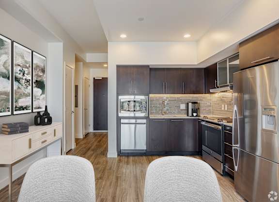 A modern kitchen with a stainless steel refrigerator and wooden cabinets.