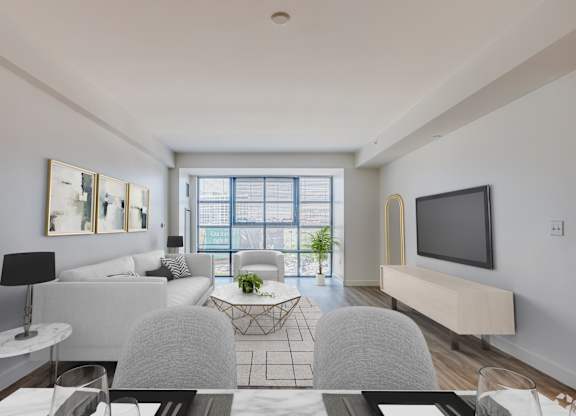 A modern living room with a grey sofa, a white coffee table, and a flat screen TV.