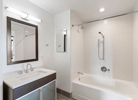 A white bathroom with a white tub and a white sink.
