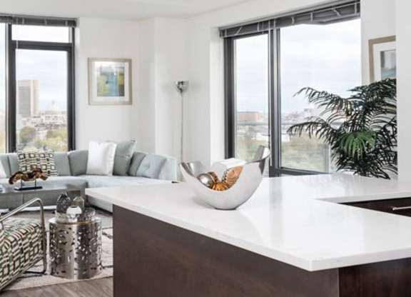 A modern kitchen with a large island and a view of the city.
