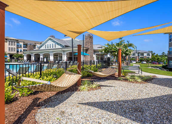 A yellow canopy over a gravel area with a hammock.