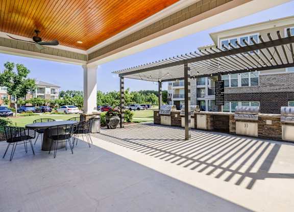 A patio with a table and chairs under a roof.