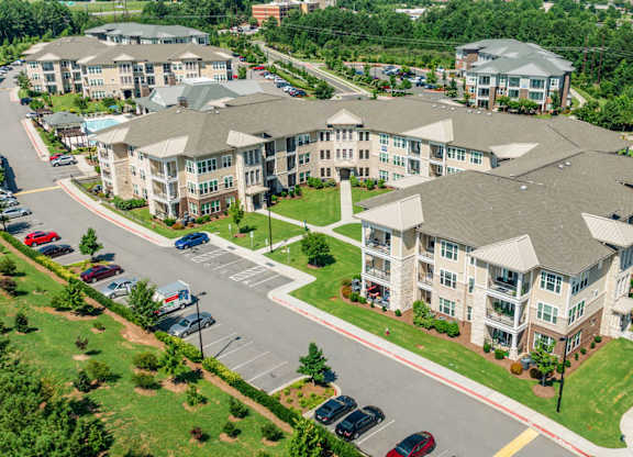 A large apartment complex with a parking lot in front.