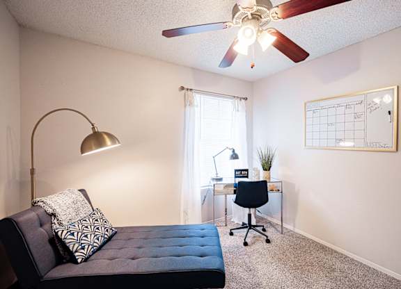 A bedroom with a bed, desk, and chair.