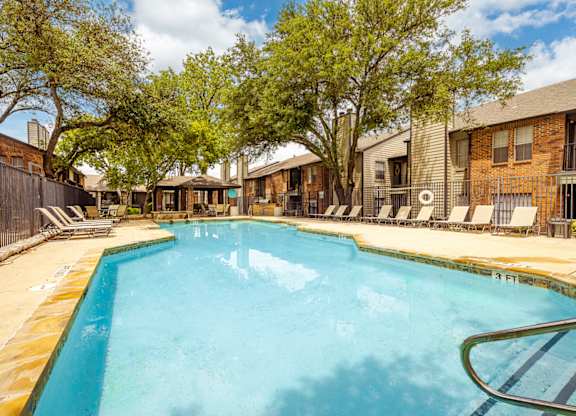 A swimming pool surrounded by trees and a fence.