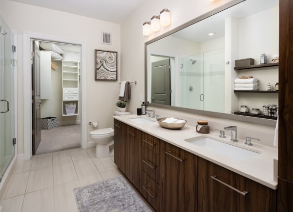 a bathroom with a large mirror and a sink and a toilet
