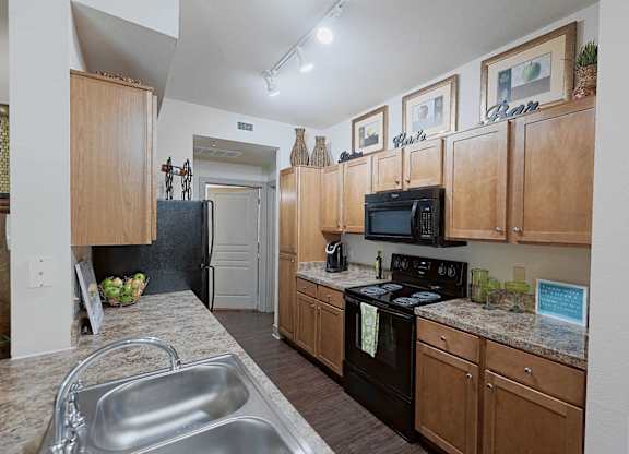 A kitchen with wooden cabinets and a black stove top oven.